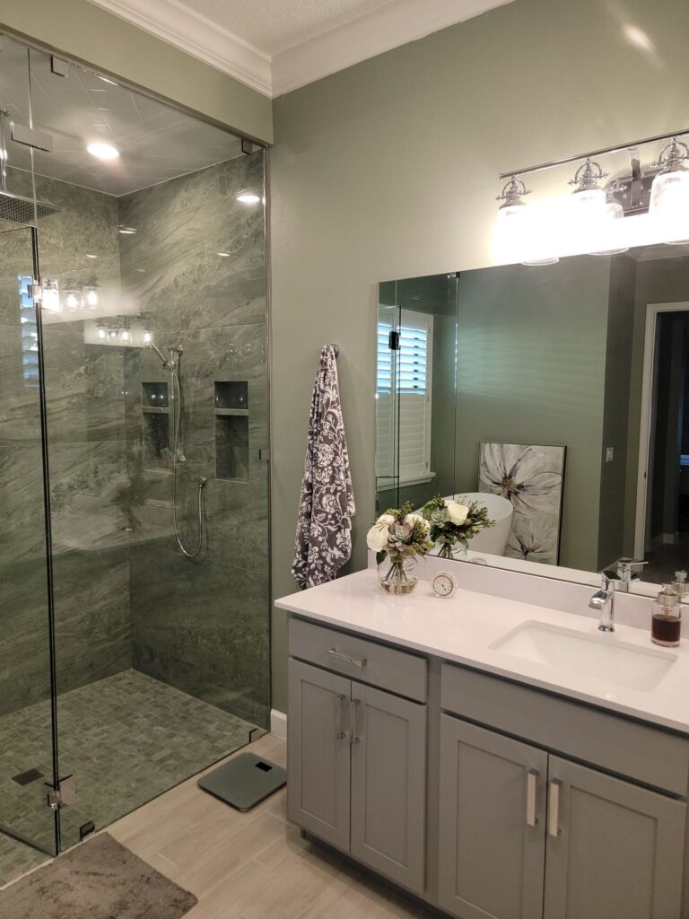 Bathroom remodel with glass walk-in shower and gray vanity