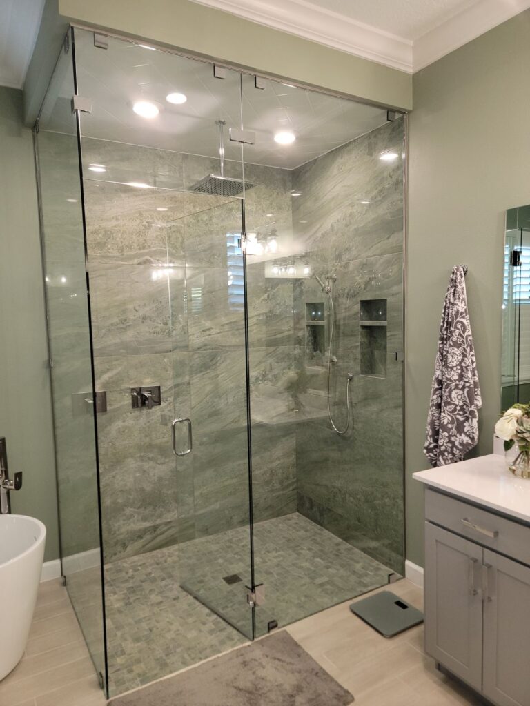 Frameless glass walk-in shower with large green tile