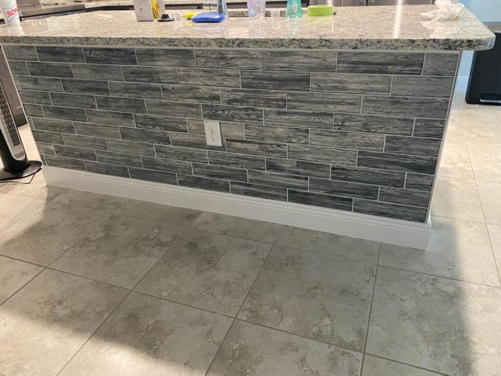 Kitchen island with stacked stone panel and tile floor