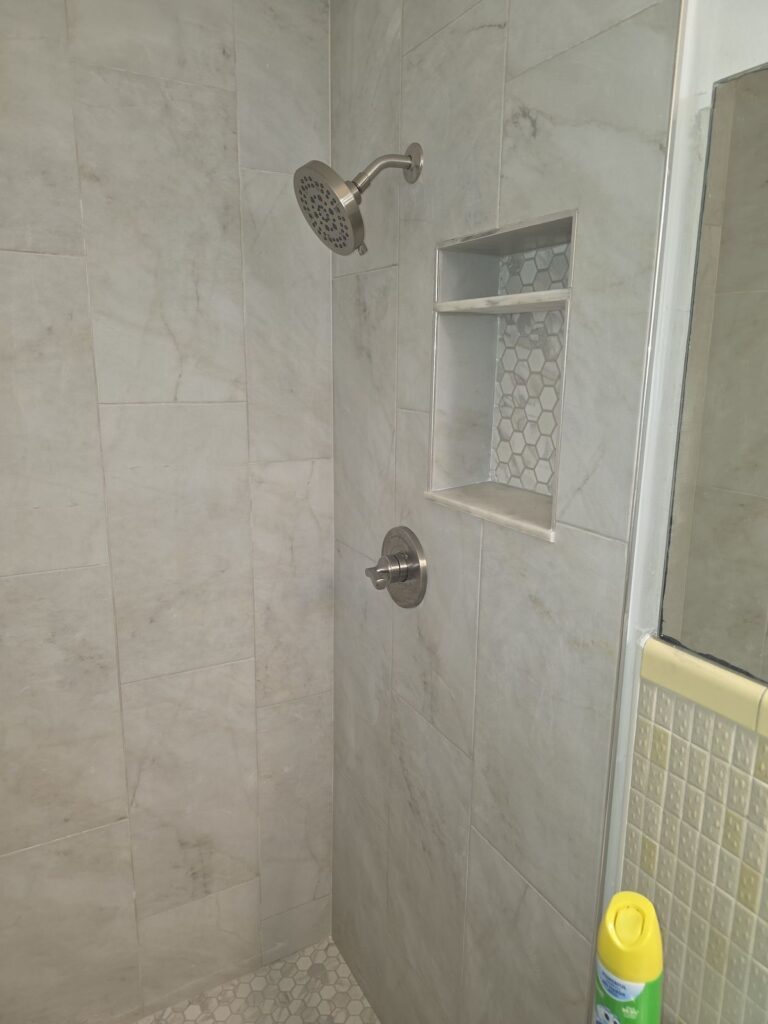 Tile shower with recessed niche and hex floor